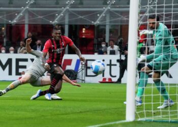 Milan beats Genoa to hold Serie A summit