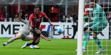 Milan beats Genoa to hold Serie A summit