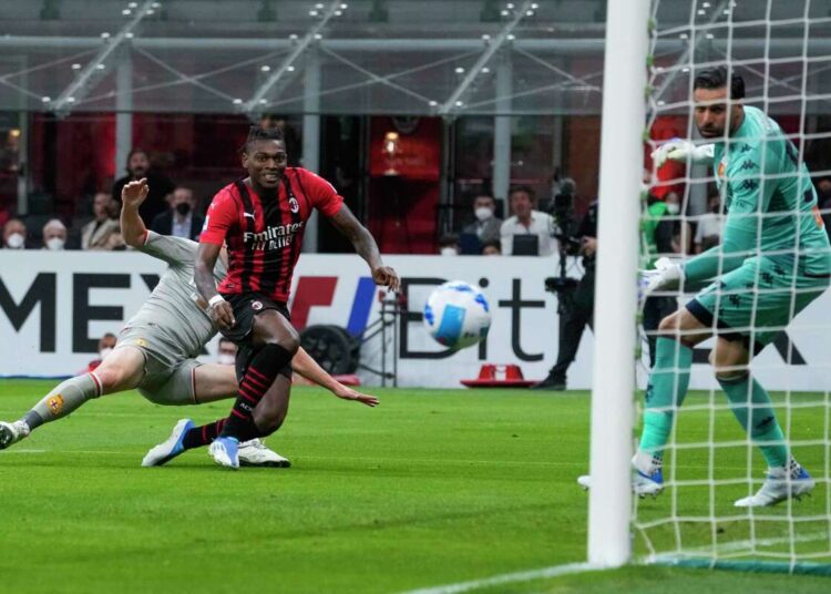 AC Milan's Rafael Leao (L) shoots the ball to score past Genoa's goalkeeper Salvatore Sirigu the opening goal during their Serie A match in Milan.