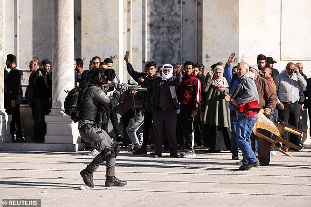 Israeli forces arrest 400 Palestinian worshippers from Al-Aqsa Mosque 1 - Egyptian Gazette An Israeli security forces member moves in position during clashes with Palestinian protestors at the compound that houses Al-Aqsa Mosque