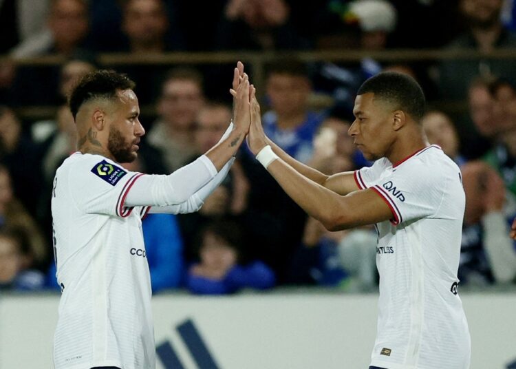 Paris St Germain's Kylian Mbappe celebrates with Neymar after scoring the third goal against RC Strasbourg.