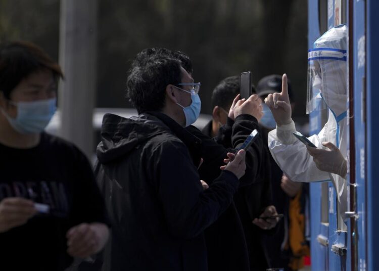 Covid outbreak ‘extremely grim’ as Shanghai extends lockdown 1 - Egyptian Gazette Residents talking to a health worker and they line up to get their throat swab at a coronavirus testing site Tuesday.