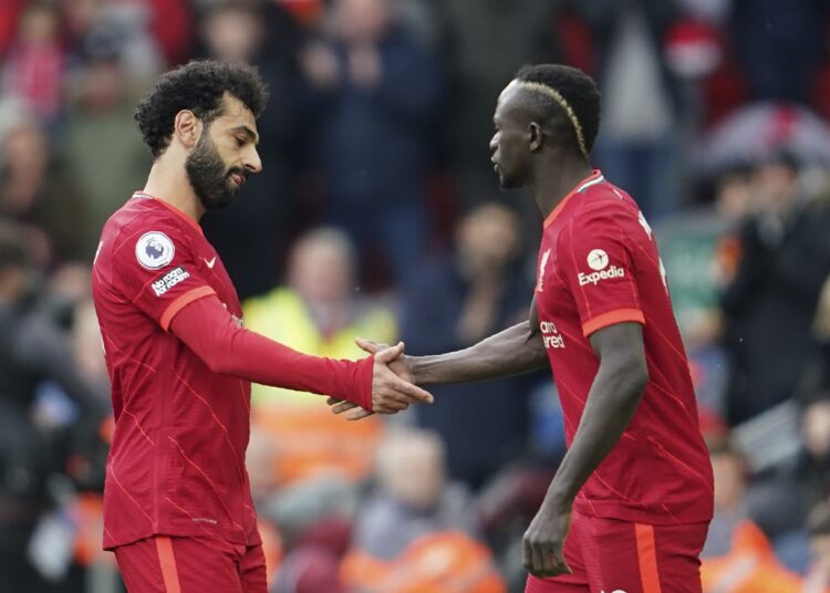 Liverpool's Mohamed Salah (L) leaves the field as his teammate Sadio Mane enters against Watford at Anfield stadium.