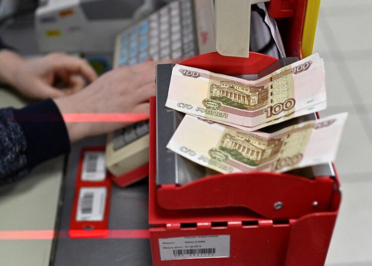 Russian 100-rouble banknotes are placed on a cashier's desk at a supermarket in the Siberian town of Tara in the Omsk region, Russia, on December 14, 2021.