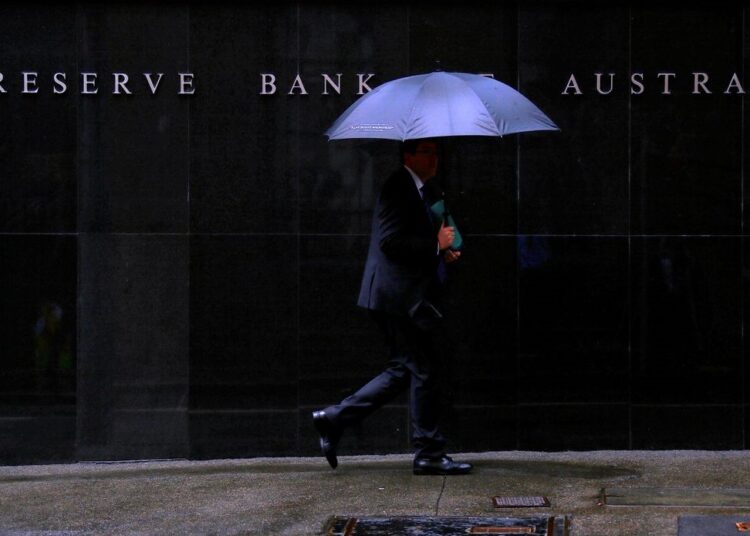 A file photo shows pedestrians walk past the Reserve Bank of Australia building in central Sydney, Australia.
