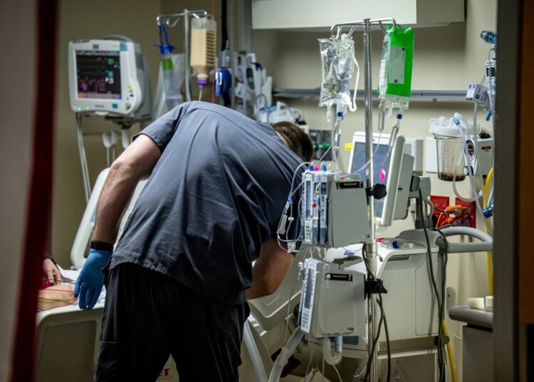A nurse checks on a COVID-19 patient in the intensive care unit at Saint Claire Regional Medical Center in Morehead, Kentucky, on Dec. 1, 2021.