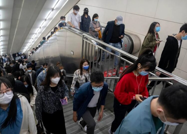 Shanghai easing virus rules 1 - Egyptian Gazette Commuters wearing face masks walk in a subway station in Beijing on April 22, 2022.