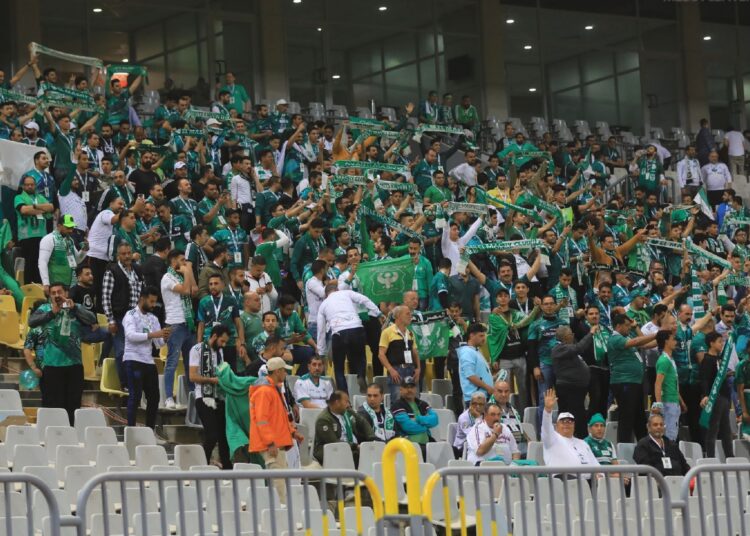 Al-Masry supporters cheer for their team during the CAF Confederation Cup quarter-final first-leg match against RS Berkane at the Borg el-Arab Stadium.