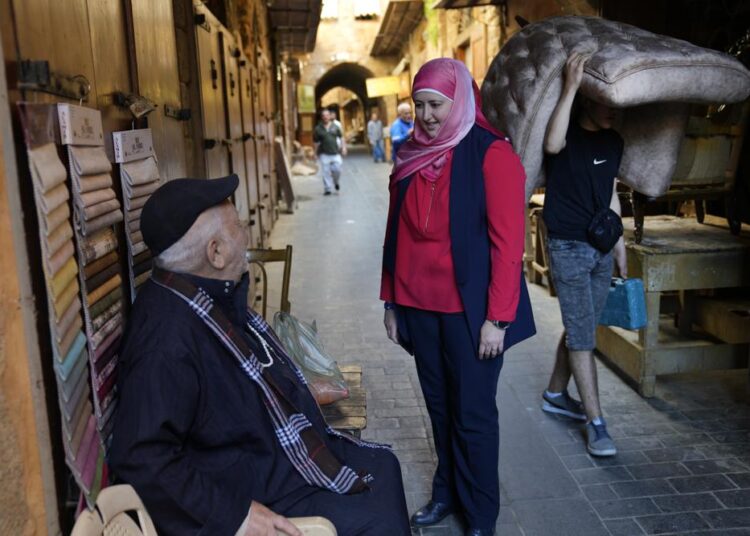 Hania Zaatari, center, who is an independent candidate in the upcoming parliamentary elections tells a man that fixing Lebanon's devastating economic crisis is her top priority, at the old souk, in Sidon, Lebanon, April 9, 2022.