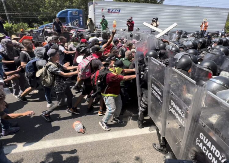Migrants march from south Mexico as US lifts COVID ban 1 - Egyptian Gazette Migrant break through a line of National Guards trying to block them from leaving Tapachula, Mexico, on April 1, 2022.