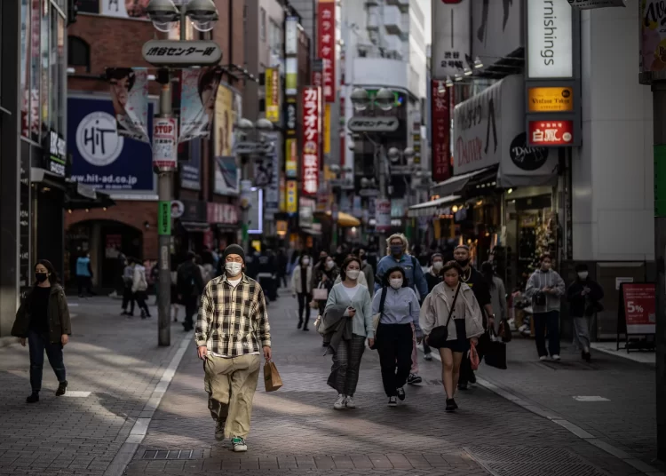 People walking along a shopping street in Tokyo.