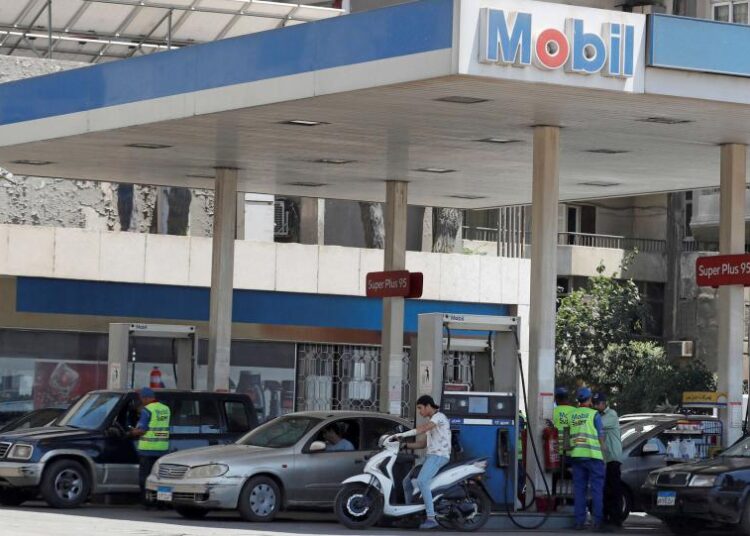 A file photo shows vehicles are being filled up with fuel by employees at a Mobil petrol station in Cairo, Egypt.