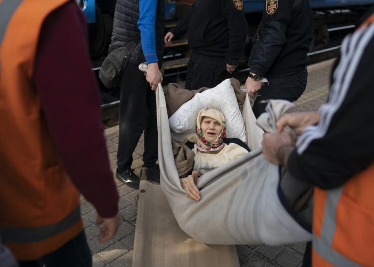 Russia pounds eastern Ukraine as West promises Kyiv new arms 1 - Egyptian Gazette A 91-year-old woman is carried on an improvised stretcher as she boards a train, fleeing the war in Severodonetsk at a train station in Pokrovsk, Ukraine.