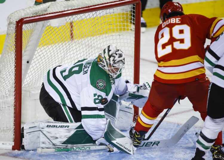 Dallas Stars goalie Jake Oettinger (L) stops a shot from Calgary Flames Dillon Dube during their NHL Stanley Cup first-round playoff series in Calgary.