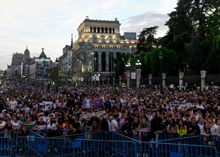Real Madrid's supporters gather to celebrate on the Plaza Cibeles square in Madrid, after Real Madrid CF won the Spanish League football match against RCD Espanyol on April 30, 2022. - Real Madrid secured a 35th La Liga title with four games to spare after a 4-0 home win over Espanyol that included two goals from Rodrygo. Needing just one point to clinch the trophy, Madrid struck twice through the Brazilian in the first half at the Santiago Bernabeu before further goals from Marco Asensio and Karim Benzema. (Photo by OSCAR DEL POZO / AFP)