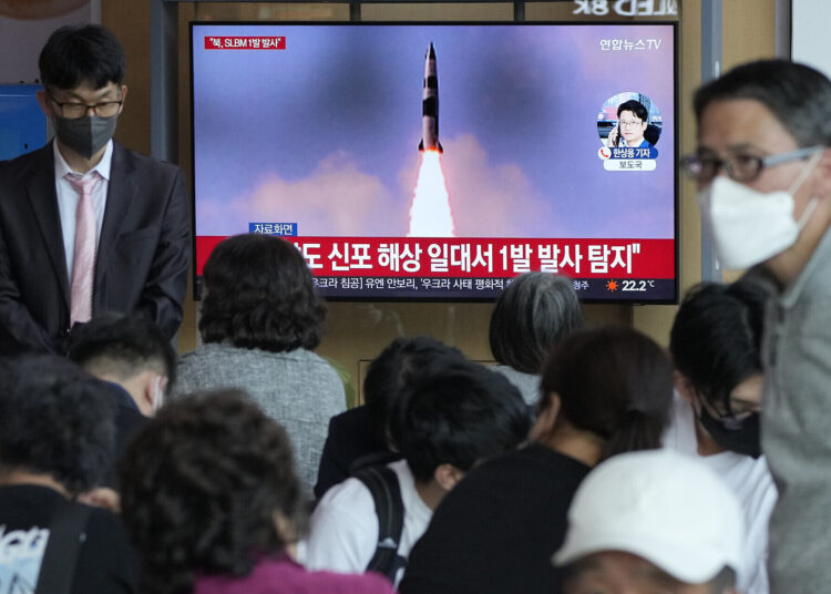 People watch a TV showing a file image of North Korea's missile launch during a news programme at the Seoul Railway Station in Seoul, South Korea, Saturday, May 7, 2022.