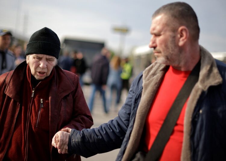 Ukraine, UN and Red Cross make new effort to evacuate civilians from Mariupol 1 - Egyptian Gazette A Ukrainian woman evacuee from Mariupol walks with her son after arriving at a registration centre for internally displaced people in Zaporizhzhia, Ukraine May 3, 2022.