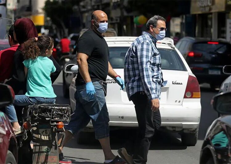 Men wearing protective face masks walk in downtown Cairo, amidst concerns about the spread of the coronavirus disease, Egypt, taken.
