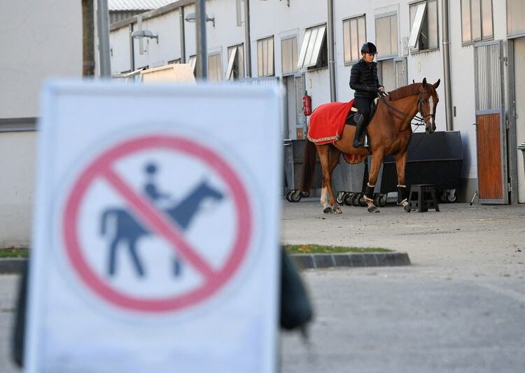 FILE PHOTO: A rider with her horse are seen next to a no riding zone sign during a news conference about keeping horse riding in the modern pentathlon program in Budapest, Hungary, November 12, 2021. REUTERS / Marton Monus/File Photo