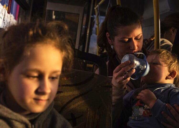 People with children wait after arriving from the Ukrainian city of Mariupol at a center for displaced people in Zaporizhzhia, Ukraine, on Tuesday, May 3, 2022.