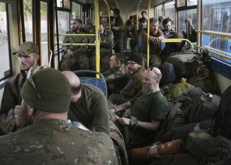 Ukrainian servicemen sit in a bus after they were evacuated from the besieged Mariupol's Azovstal steel plant, near a prison in Olyonivka, in territory under the government of the Donetsk People's Republic, eastern Ukraine, on Tuesday, May 17, 2022.