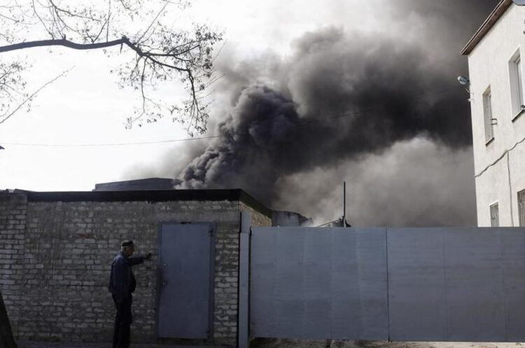 Russia says civilians killed in shelling by Ukraine near Kherson - RIA news agency 1 - Egyptian Gazette A person rings the bell outside a burning plant, following Russian shelling amid Russia's attack on Ukraine, in Kharkiv, Ukraine, April 30, 2022.