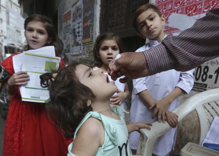 A health worker gives a polio vaccine to a child in a neighborhood of Lahore, Pakistan, Monday, May 23, 2022. Pakistan launched a new anti-polio drive on Monday, more than a week after officials detected the third case so far this year in the country's northwestern region bordering Afghanistan.