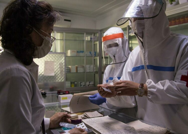 N. Korea says Covid outbreak under control 1 - Egyptian Gazette A doctor with North Korea's army visits a pharmacy in Pyongyang to give a woman medication.