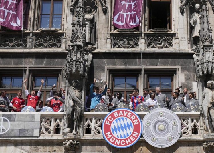 Bayern goalkeeper Manuel Neuer lifts the trophy besides his teammates on the balcony of the town hall at Marienplatz square celebrating the 31th Bundesliga title at the German Bundesliga in Munich, Germany, Sunday, May 15, 2022.