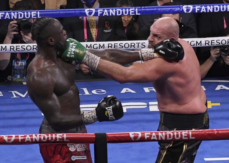 Tyson Fury (R) punches Deontay Wilder during the World Heavyweight Championship fight in Las Vegas, Nevada on October 9, 2021.