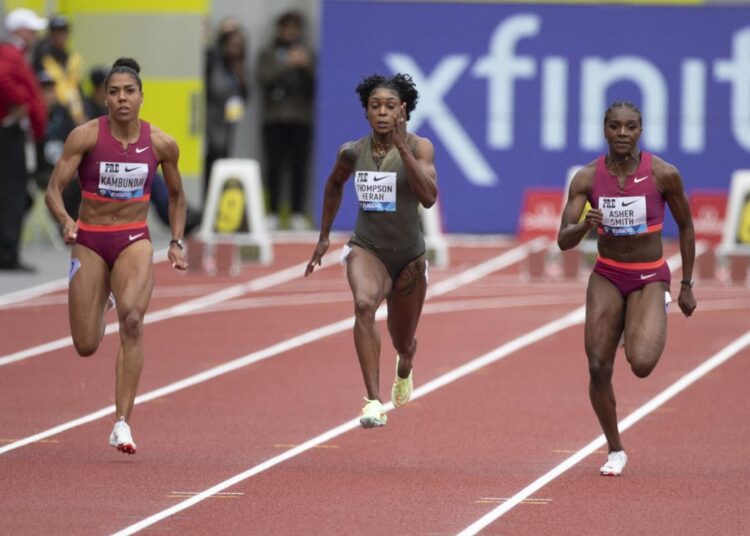 Jamaica's Elaine Thompson-Herah (C) crosses the finish line to win the women's 100m final at the Diamond League in Rabat.