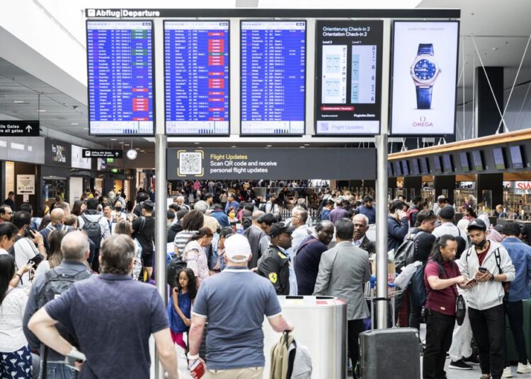 Switzerland reopens airspace after ‘technical malfunction’ 1 - Egyptian Gazette Passengers wait in front of a display board at Zurich airport, in Zurich, Wednesday, June 15, 2022.
