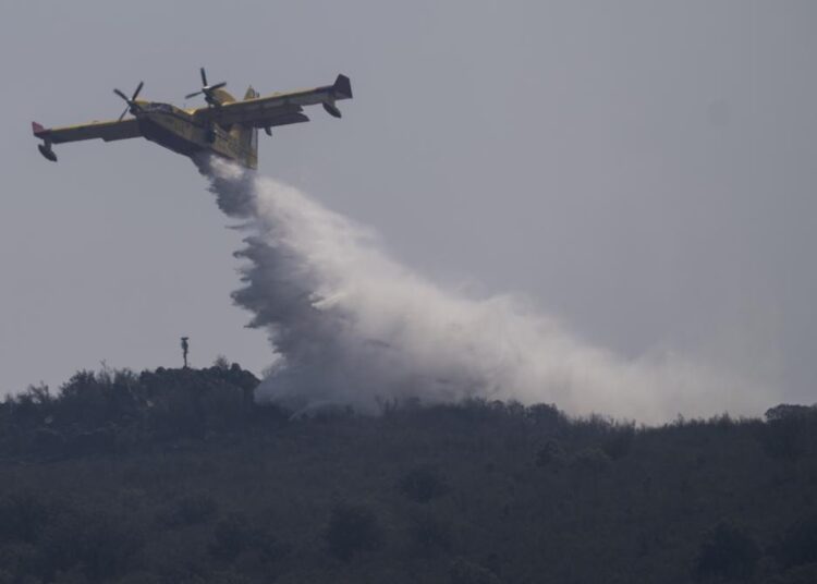 A firefighting plane drops water during fire extinguish works near Tabara, north-west Spain, yesterday.