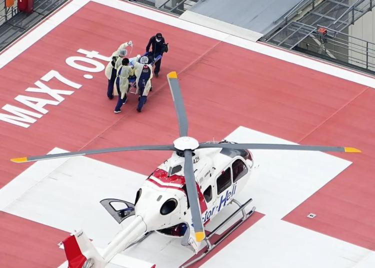 A patient, believed to be Japan's former Prime Minister Shinzo Abe, is carried on a stretcher on arrival by medical helicopter at a hospital in Kashihara, Nara prefecture, western Japan Friday, July 8, 2022. Abe was shot during a campaign speech Friday in western Japan and was airlifted to a hospital but he was not breathing and his heart had stopped, officials said.