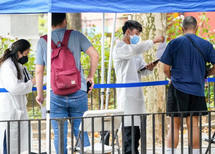 Healthcare workers with New York City Department of Health and Mental Hygiene help people register for the monkeypox vaccine at one of the City's vaccination sites on July 26, 2022, in New York.