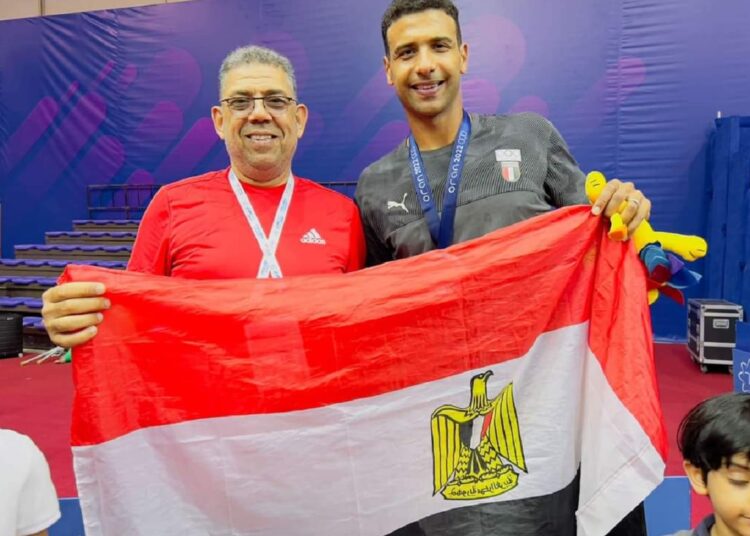 Omar Asr (R) posing with the men's singles silver medal in table tennis competitions.