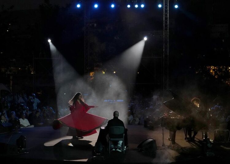 French Pianist Simon Ghraichy performs next to French-Iranian dancer Rana Gorgani during a concert in the ancient northeastern city of Baalbek, Lebanon, Sunday, July 17, 2022. Lebanon's renowned Baalbek Festival is back, held in front of a live audience for the first time in two years amid an ongoing economic meltdown.