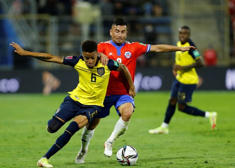 Ecuador's Byron Castillo (L) in action with Chile's Jean Meneses during their South American qualifiers on November 16, 2021.