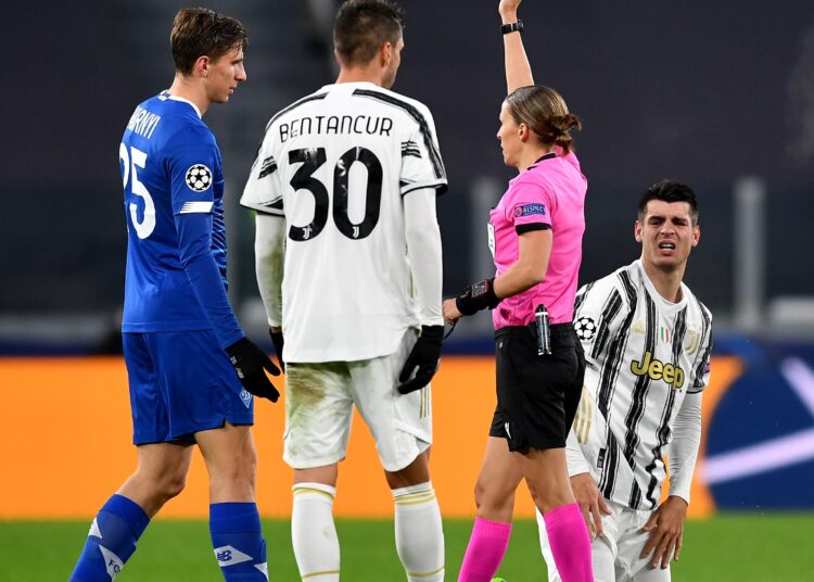 French referee Stephanie Frappart gives a yellow card to Dynamo Kiev's Nicholas Shaparenko (1st L) during a UEFA Champions League match between Juventus and Dynamo Kyiv.
