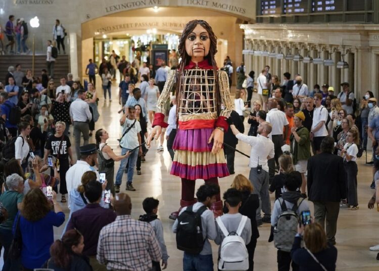 Meet Little Amal: A puppet celebrating New York City's roots 1 - Egyptian Gazette Commuters and tourists gather around a large puppet named Little Amal as she walks around Grand Central Station in New York, Thursday, Sept. 15, 2022.