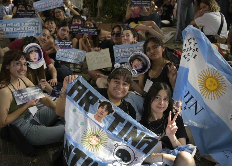 Fans of the South Korean band BTS queue to access to River Plate's Monumental stadium to attend the fourth of ten concerts of the British rock band Coldplay in Buenos Aires, on October 28, 2022. - South Korean K-Pop boy band BTS member Kim Seok-jin, also known as Jin, will perform with the British pop rock band his new solo single, "The Astronaut". (Photo by JUAN MABROMATA / AFP)