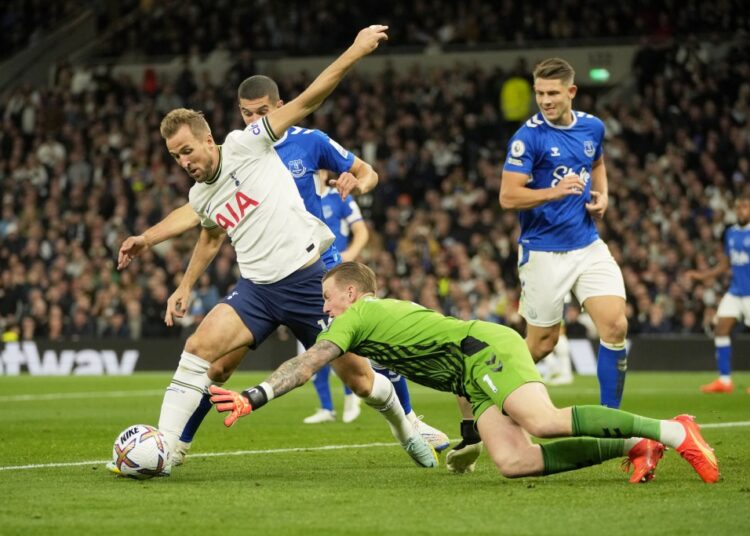Everton's goalkeeper Jordan Pickford dives for a save but ends up bringing down Tottenham's Harry Kane (L) and giving away a penalty during the English Premier League.