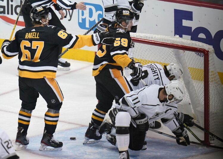 Pittsburgh Penguins' Jake Guentzel (59) scores during the first period of the team's NHL hockey game against the Los Angeles Kings in Pittsburgh.