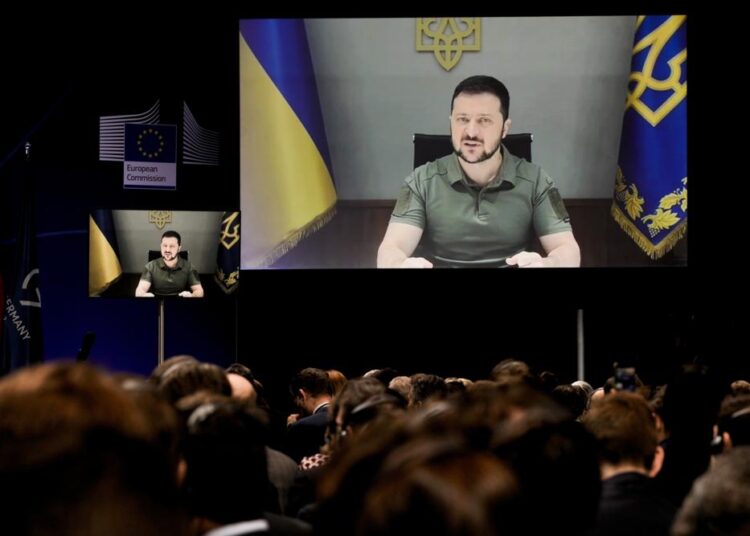 Ukrainian President Volodymyr Zelenskyy is seen on a screen as he delivers his speech during the International Expert Conference on the Recovery, Reconstruction and Modernisation of Ukraine, in Berlin, Germany, on Tuesday, October 25, 2022.