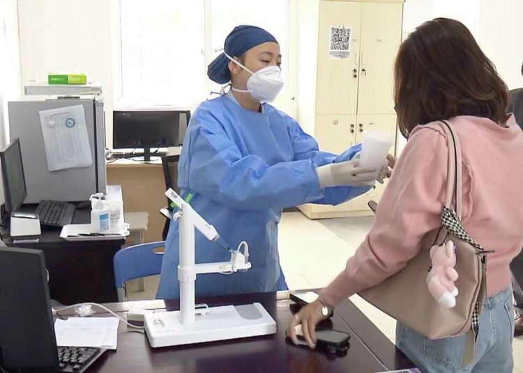 A medical worker hands over aerosolised COVID vaccine developed by Chinese biopharmaceutical company CanSino Biologics Inc. in Shanghai on Oct. 26, 2022.