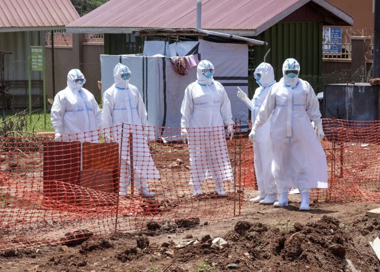 FILE - Doctors walk inside the Ebola isolation section of Mubende Regional Referral Hospital, in Mubende, Uganda on Sept. 29, 2022.