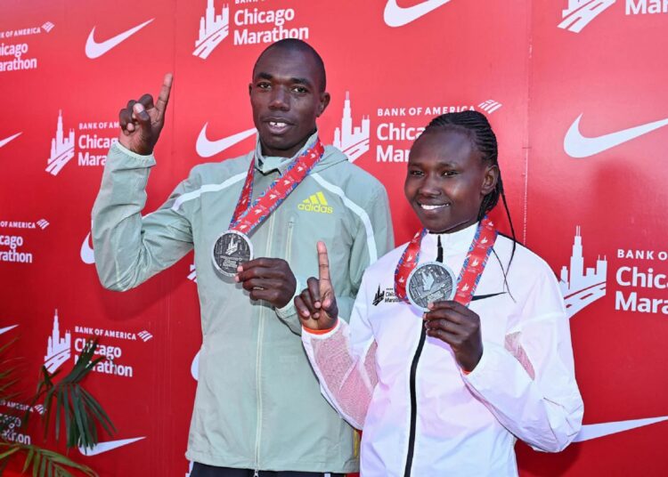 Benson Kipruto (L) and Ruth Chepngetich posing with their medals after they won the 2022 Chicago Marathon.