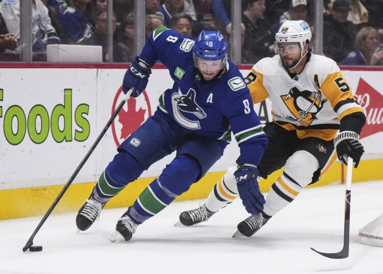 Vancouver Canucks' J.T. Miller (9) skates with the puck in front of Pittsburgh Penguins' Kris Letang (58) during the second period of an NHL game in Vancouver, British Columbia.