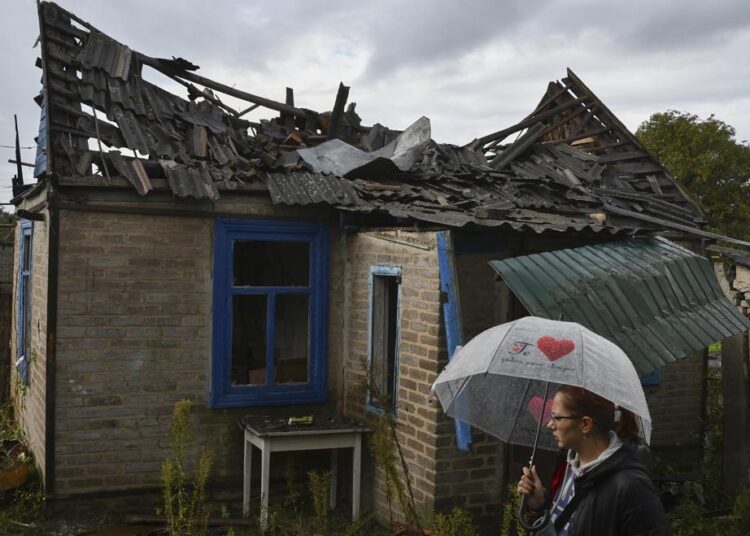 Local resident Ekaterina, 22, stands next to her residential building that was damaged after an overnight Russian attack in Kramatorsk, Ukraine, on Tuesday, October 4, 2022.