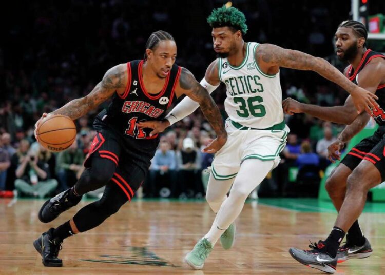 Chicago Bulls' DeMar DeRozan (L) drives past Boston Celtics' Marcus Smart (C) during their NBA game.